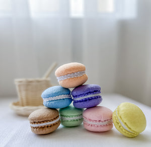 Set of seven felt tea party macarons in rainbow colours with tea cup in background