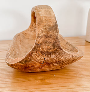 Side view showing handle of teak oblong basket displayed on wooden shelf