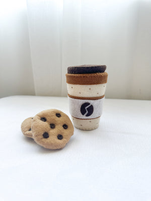 One felt coffee cup with lid in latte colour with two chocolate chip felt cookies.