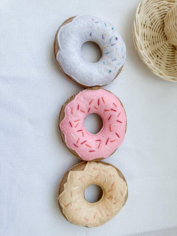 Set of three different coloured donuts with freckles on them