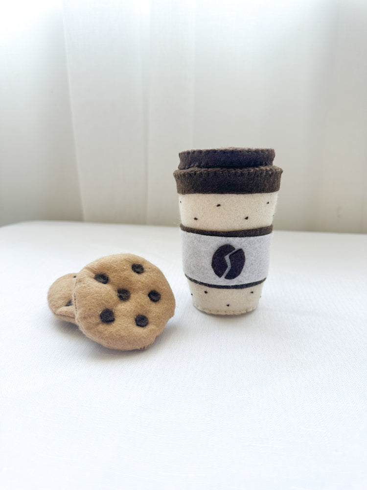 One felt coffee cup with lid in mocha colour with two chocolate chip felt cookies.