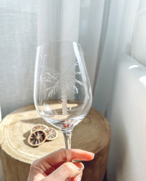 close up of clear wine glasses with an etched white palm tree