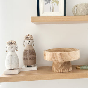 white and beige dolls sitting on wooden shelf