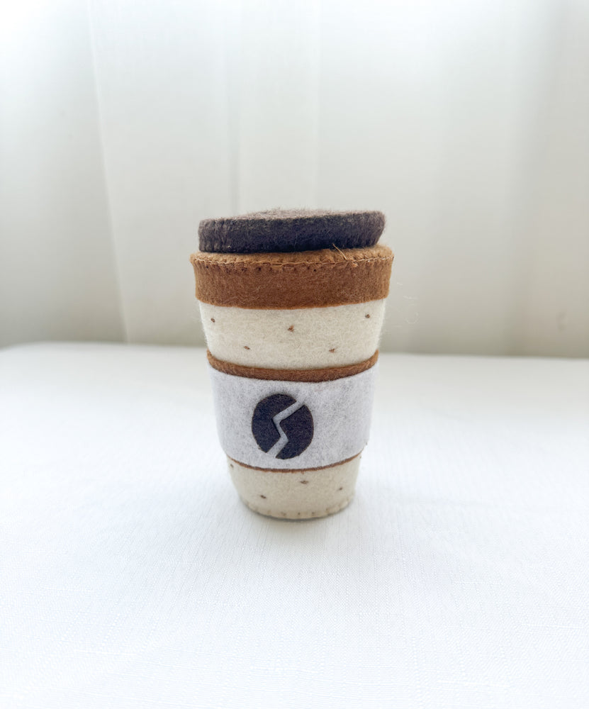 Felt coffee cup with lid in latte colour, dotted pattern top and bottom with coffee bean design on front.