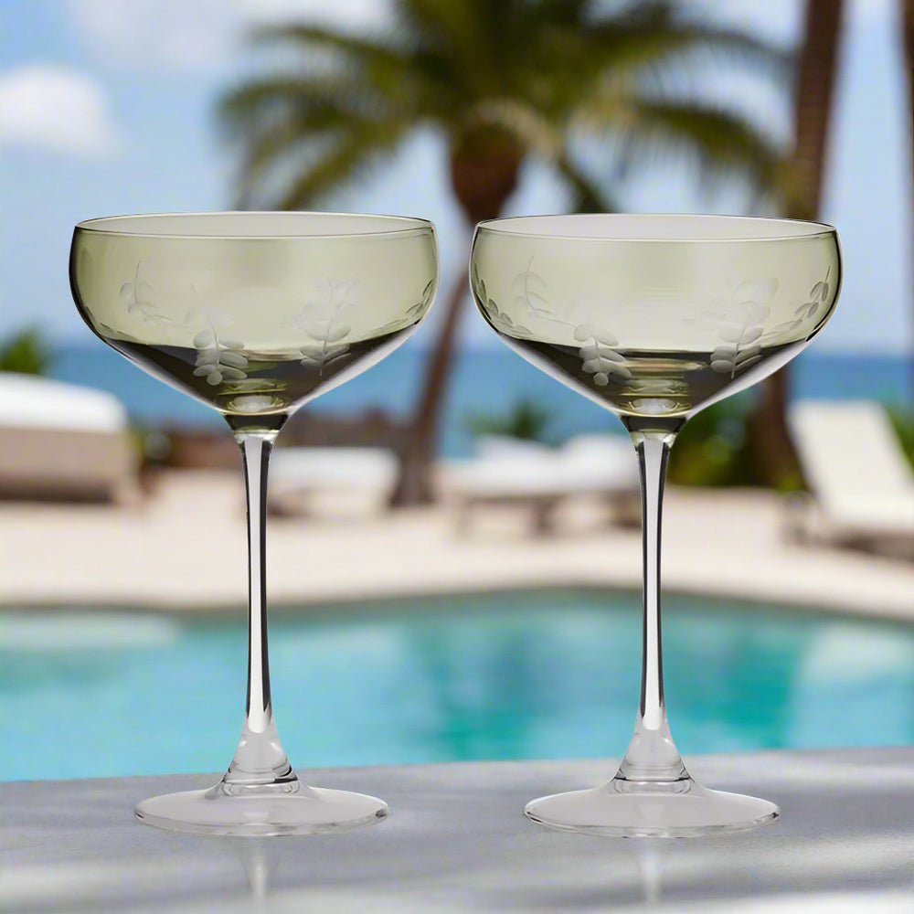 set of two tall green coupe glasses with white printed leaves on cup 