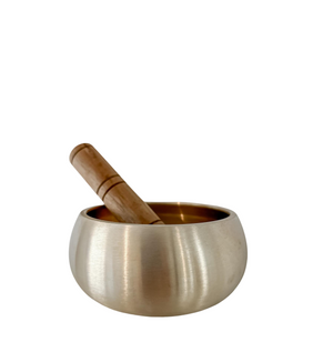 Brass singing bowl with wooden mallet inside bowl