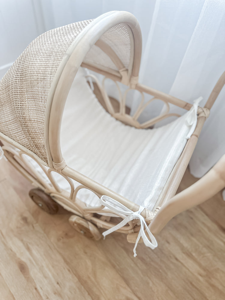Front view of handmade rattan play dolls pram Violet with linen insert - premium Balinese artisan toy featuring teak wooden wheels for children aged 3 and up