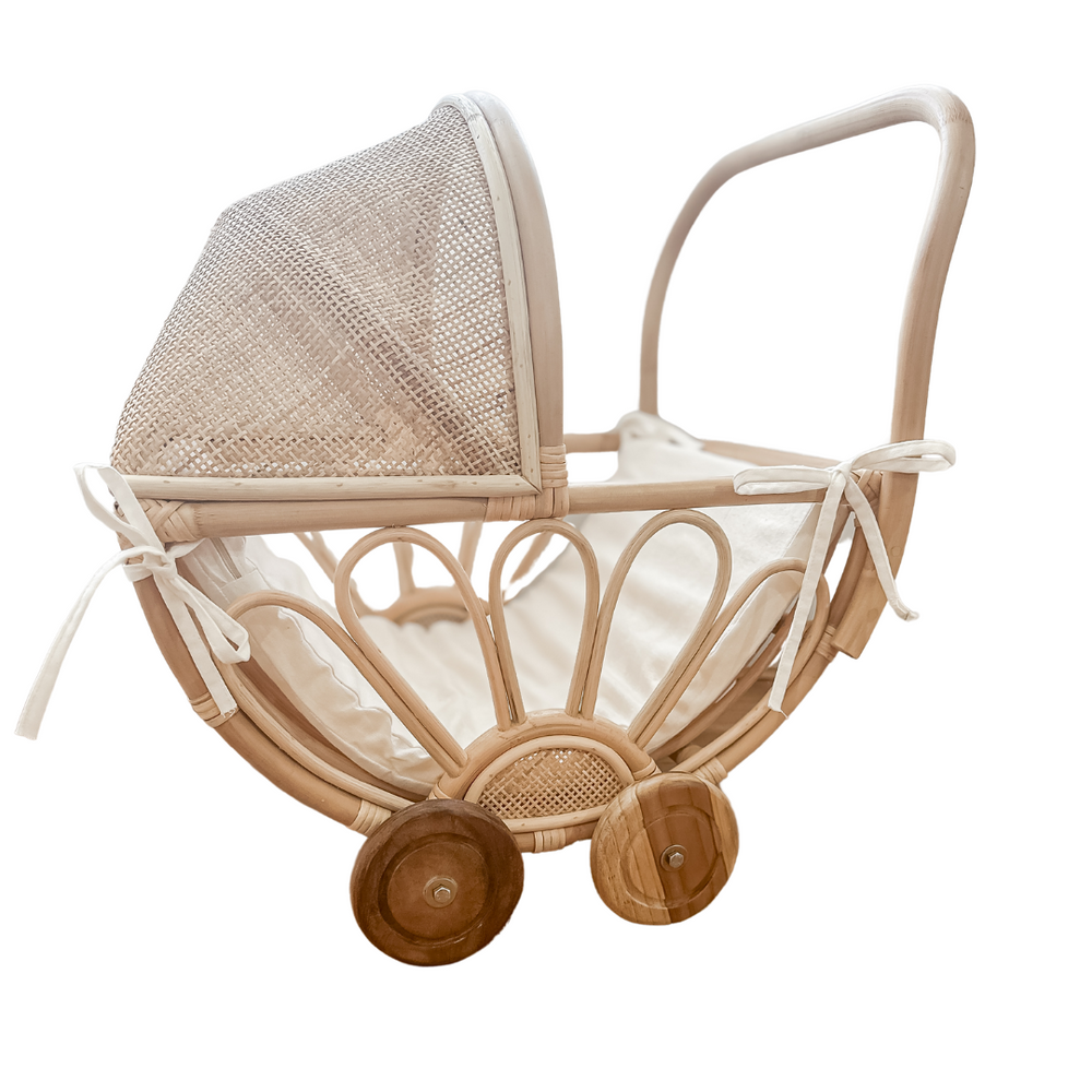 Side view of rattan dolls pram with insert on a white background