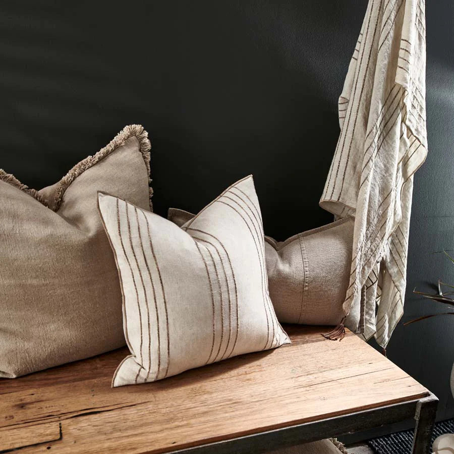 Large fringed natural linen cushion with insert displayed on bench