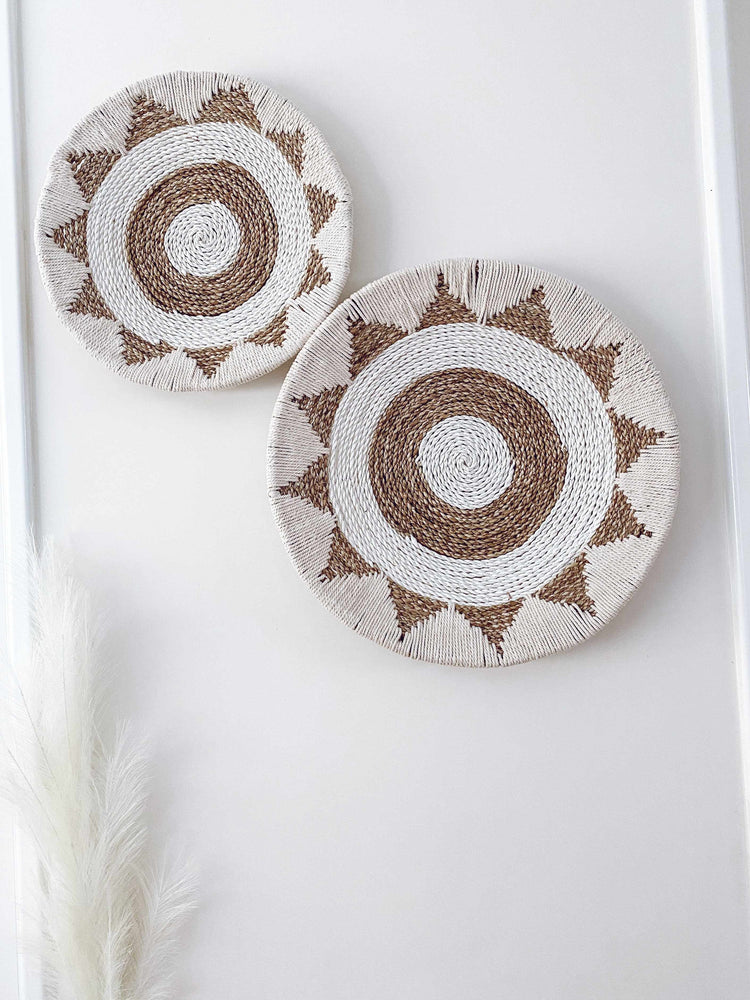 two cotton raffia and macrame wall hangings in an aztec pattern