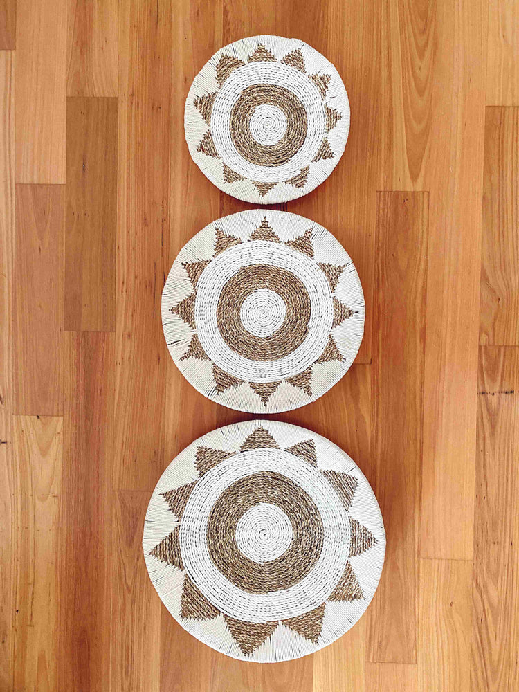 small, medium and large cotton raffia and macrame wall hangings in an aztec pattern on a wall