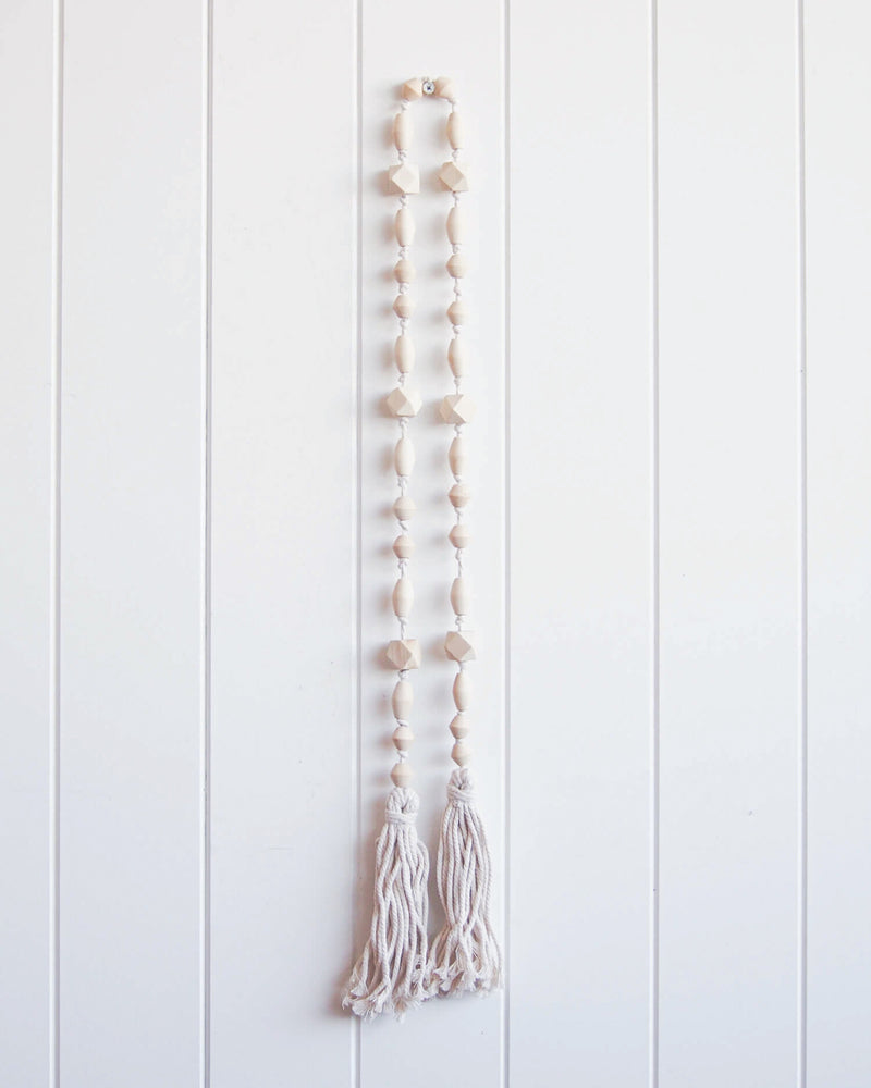 Wooden, beaded tassel hanging on wall