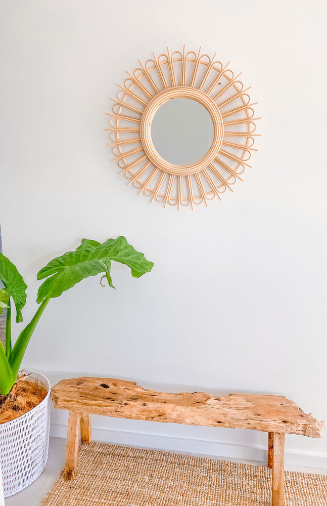 Rattan Starburst mirror on wall over wooden bench