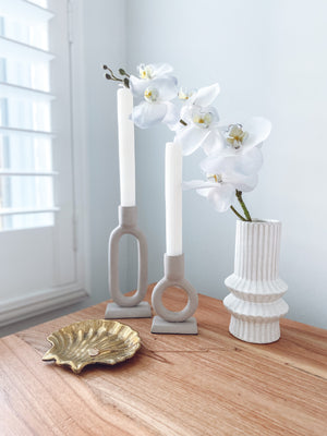 ceramic vase with candlesticks and a trinket dish displayed on a bedroom unit