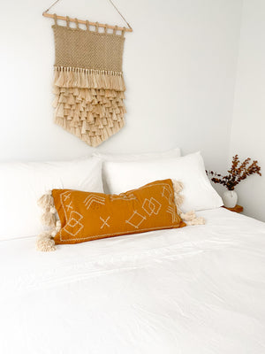 lumbar cushion with tassels on bed