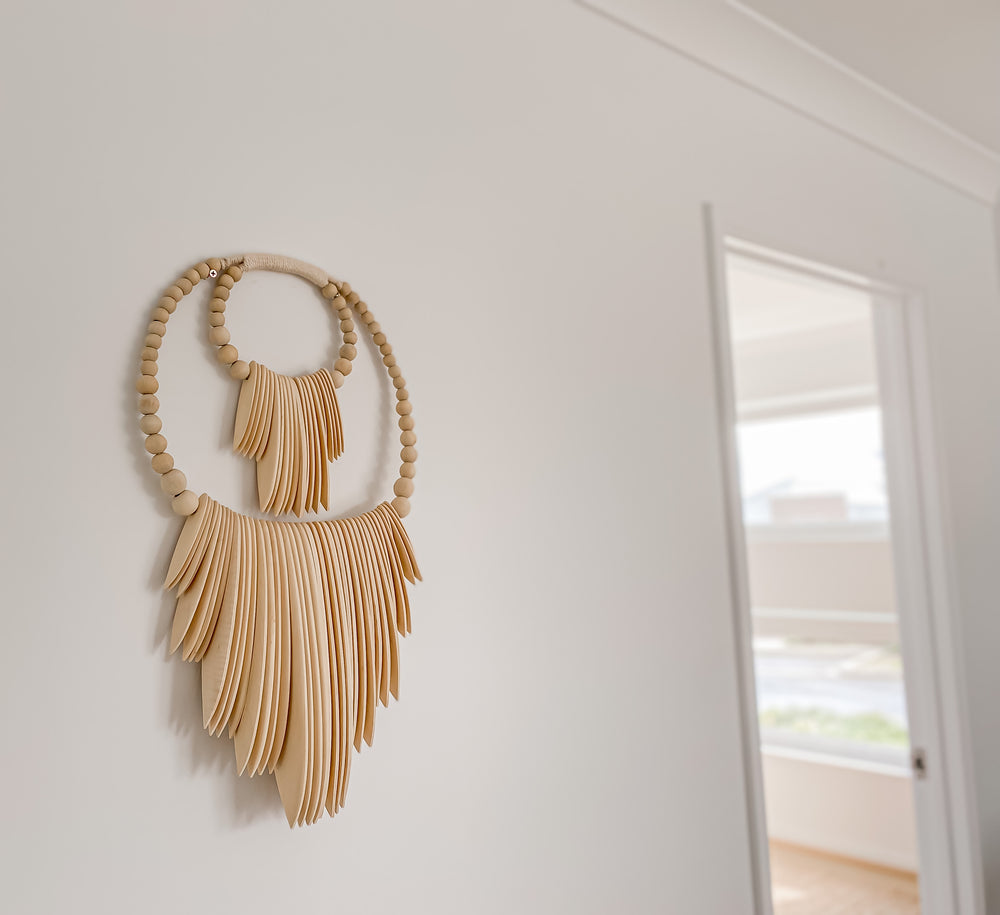 cuttlefish inspired natural wood wall hanging with beads on wall