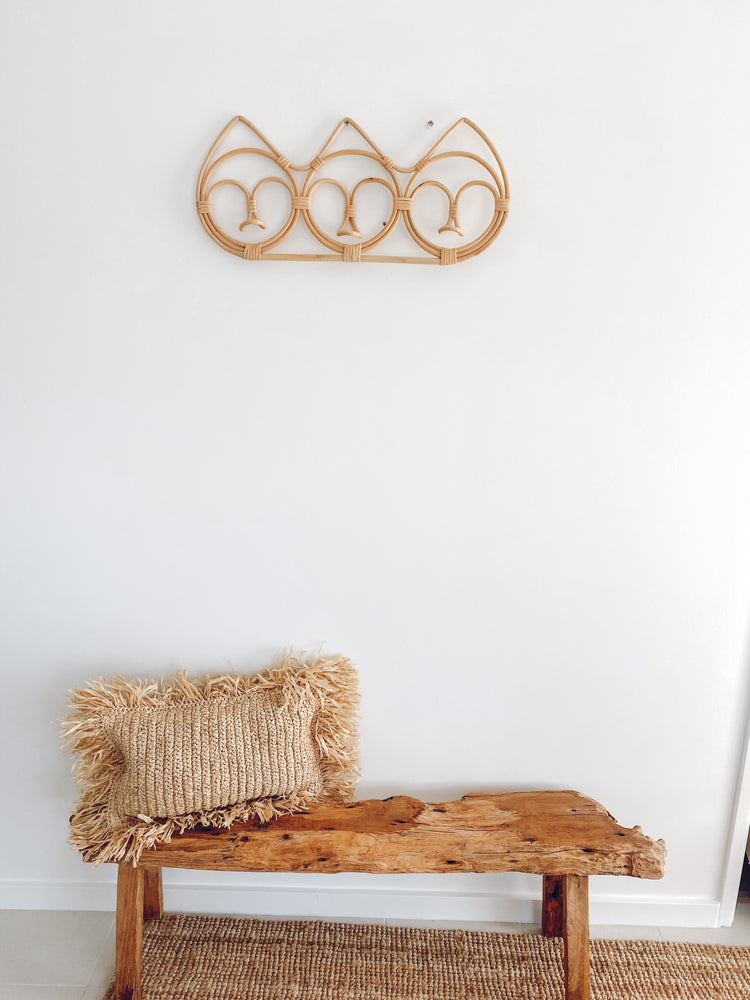 rattan wall hanger on wall over wooden bench