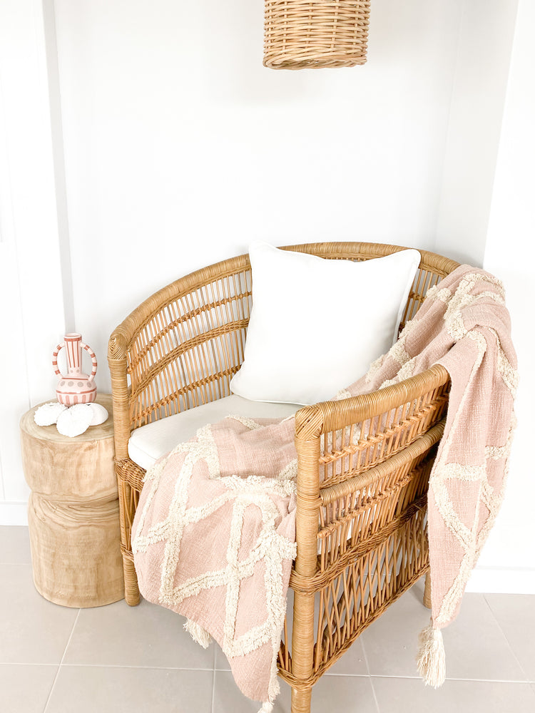 Cotton tufted throw on rattan chair