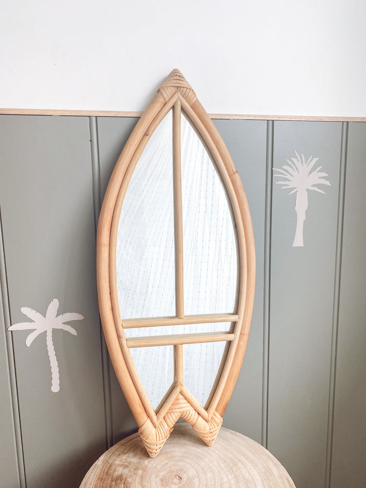 rattan surfboard mirror on top of wooden table in kids room