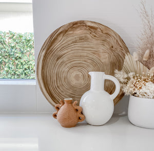 Small textured ceramic vase with two handles on each side displayed in kitchen with wooden tray and white vase