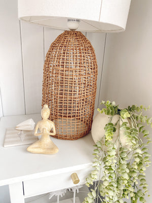 Small yoga lady displayed on table with plant in vase and rattan bedroom lamp - serene mindful home styling and decor